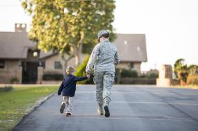military woman and child walking toward house GettyImages 664667087 1300w 867h
